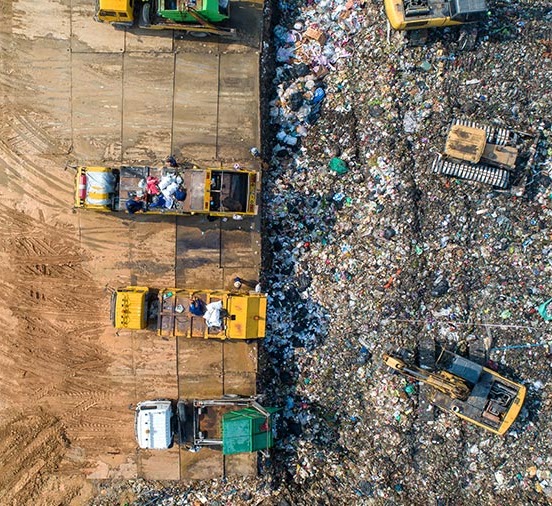 Aerial view of trucks and excavators working at a waste processing site