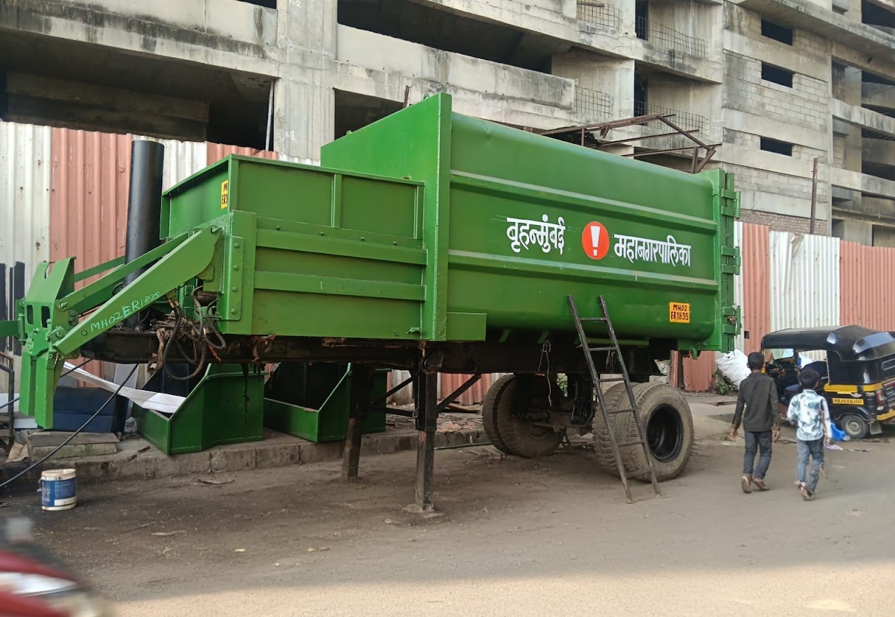 A green Brihanmumbai Municipal Corporation waste container trailer